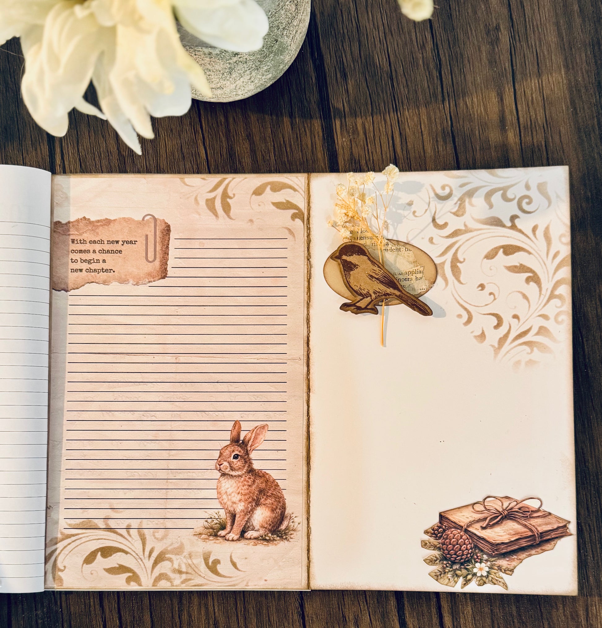 Open notebook with decorative pages featuring a rabbit illustration and floral design on a wooden surface.