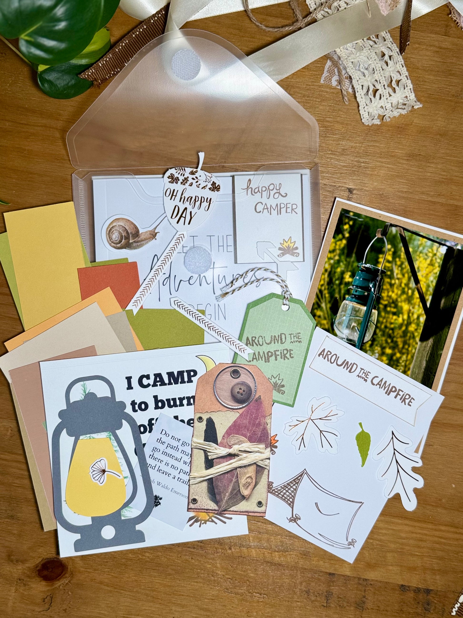 Collection of camping-themed cards and tags on a wooden surface