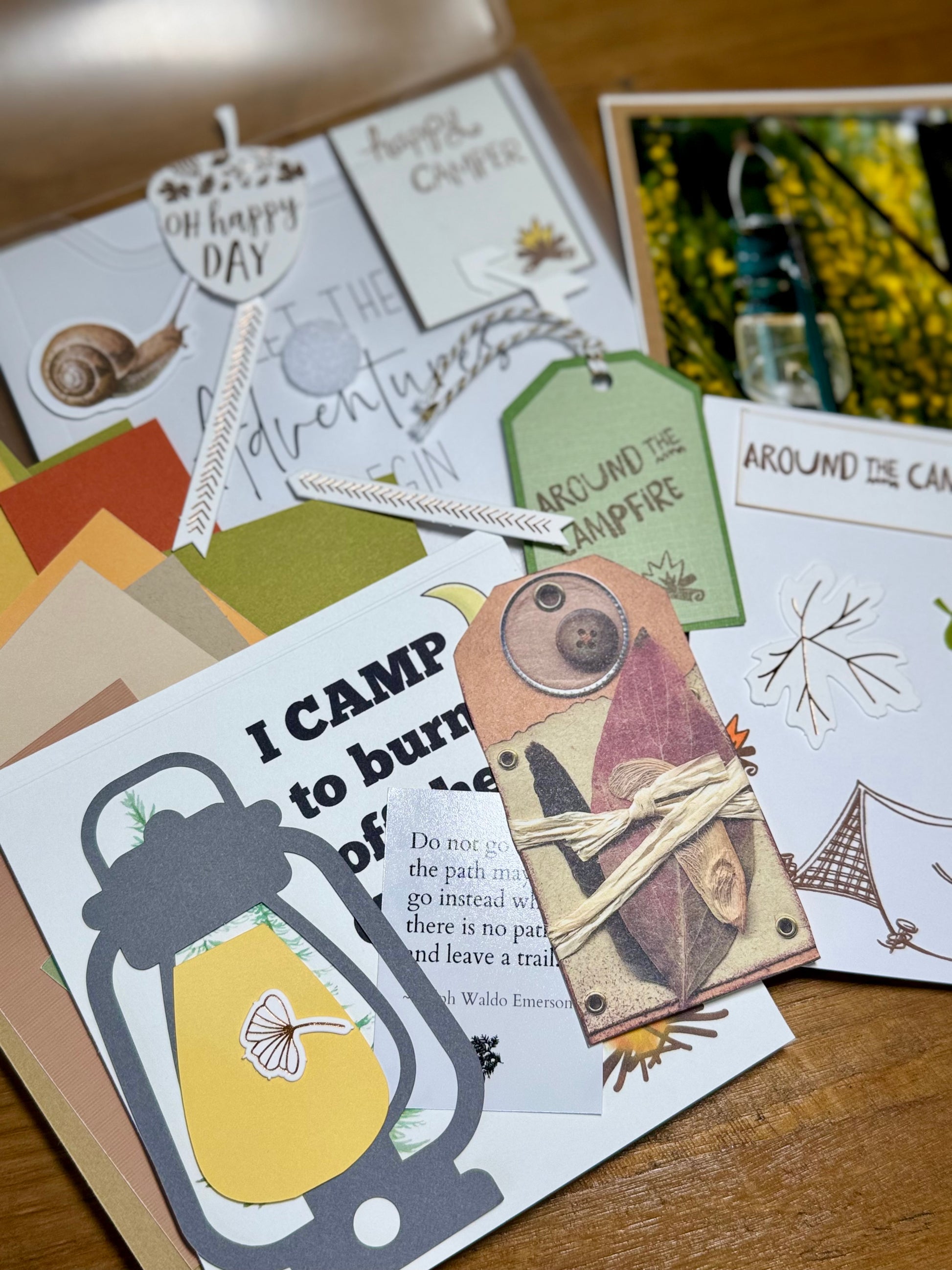 Collection of camping-themed cards and tags on a wooden surface