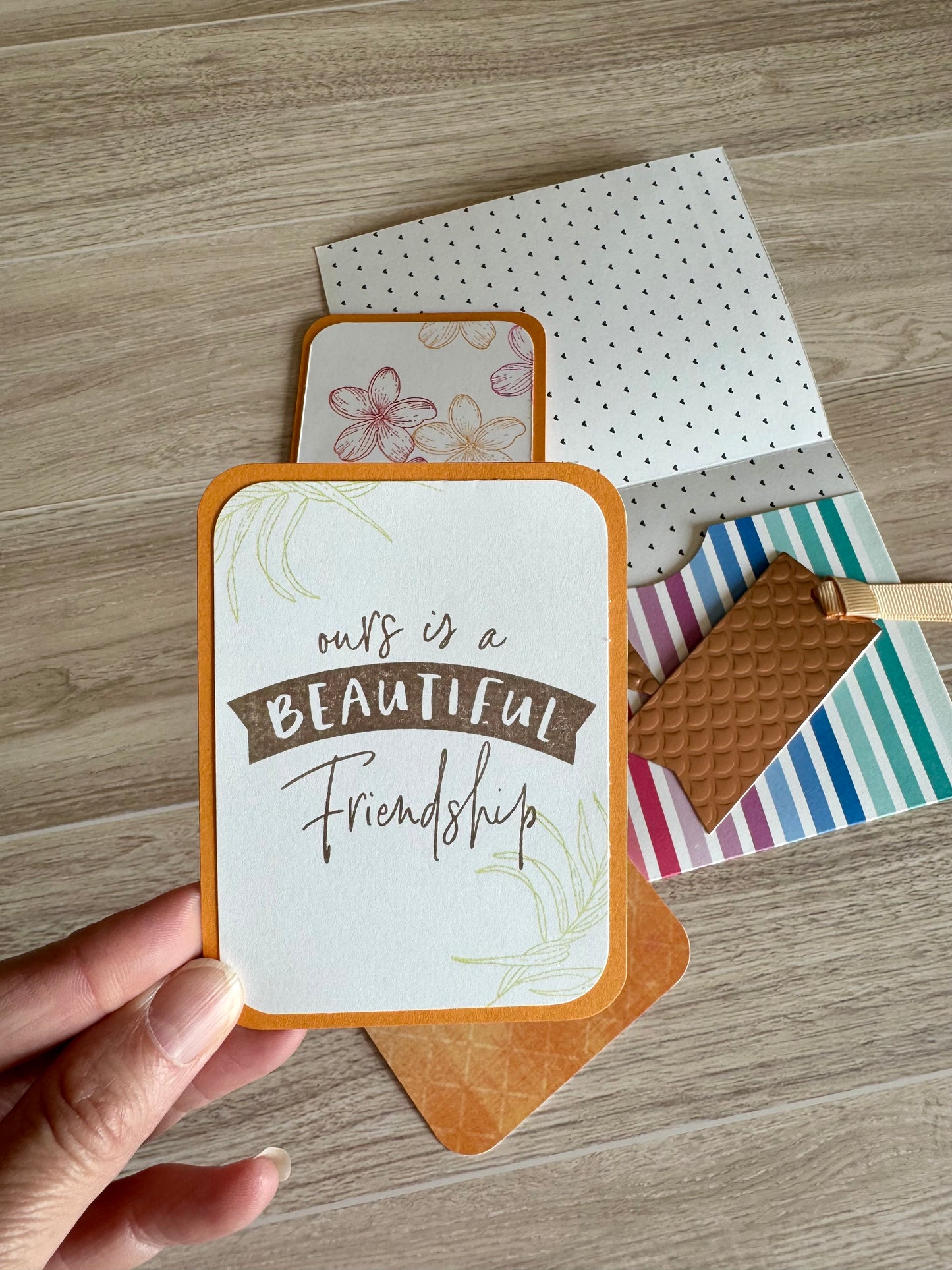 Hand holding a pocket card about friendship colored orange
