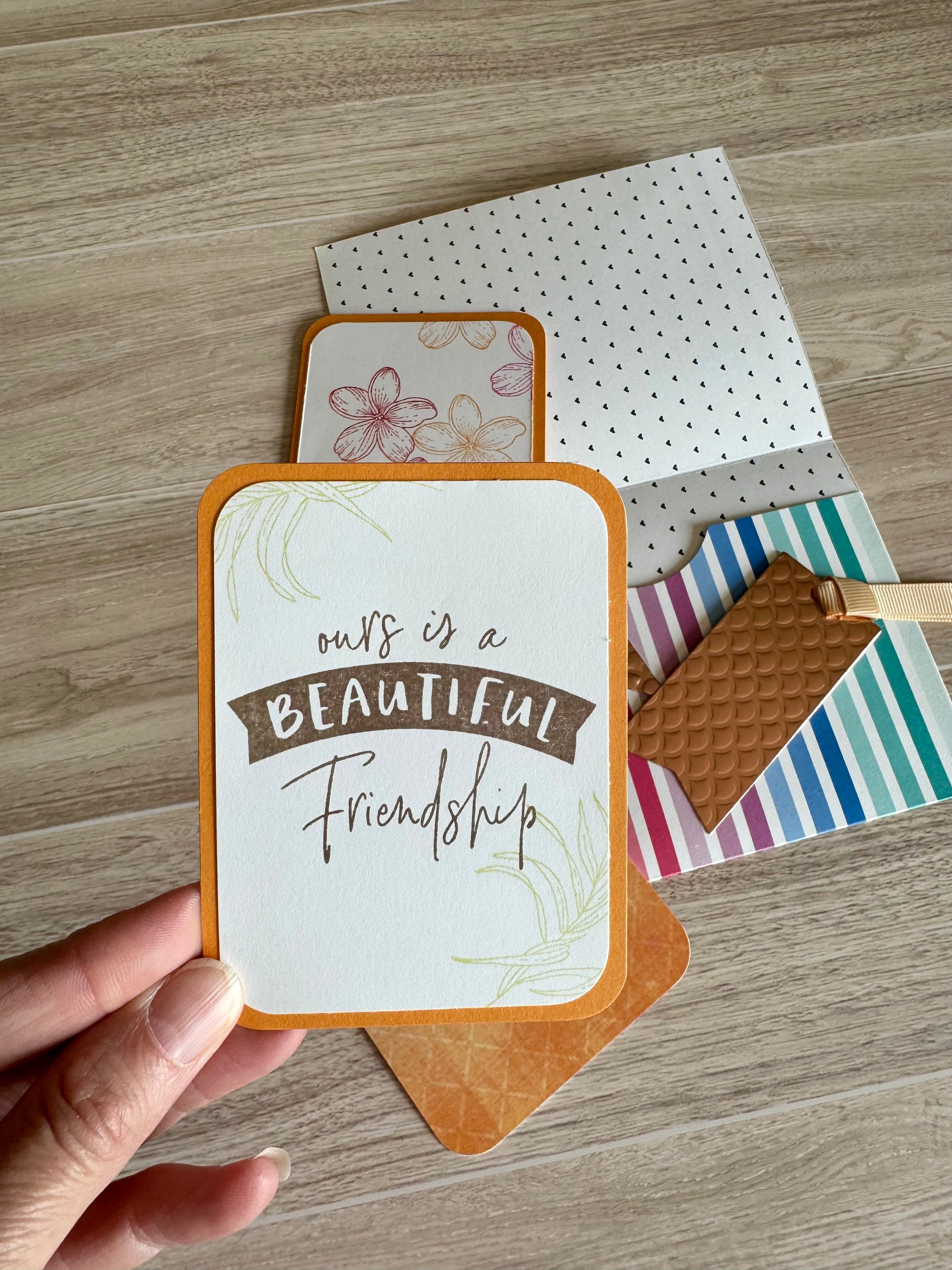Hand holding a pocket card about friendship colored orange