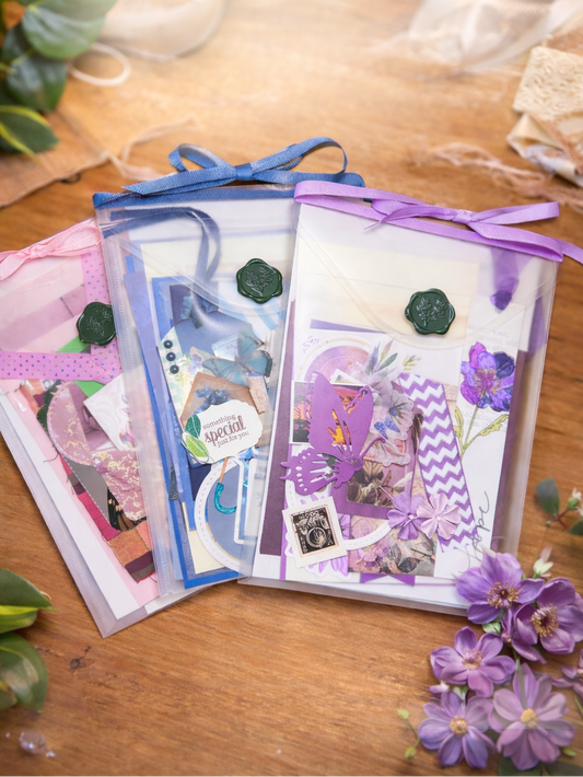 Set of junk journal kits with ribbons on a wooden surface with flowers.
