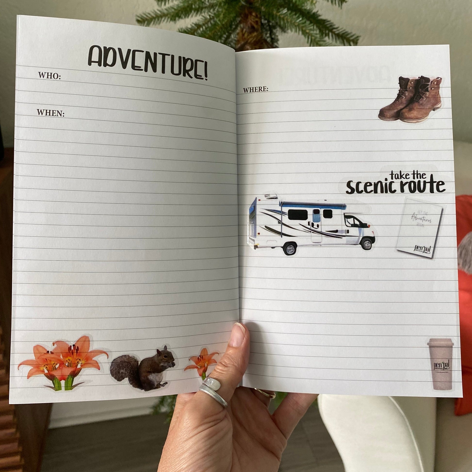 Open notebook with travel-themed pages including a camper illustration and 'Adventure!' text.
