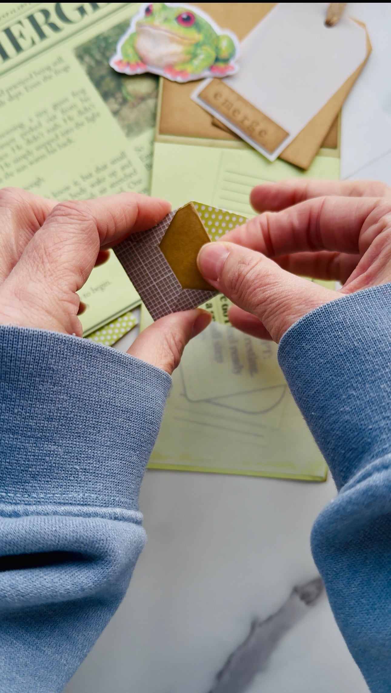 Two hands holding a small brown envelope over a newspaper background